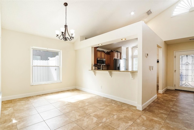 kitchen featuring stainless steel appliances, lofted ceiling, kitchen peninsula, and a breakfast bar