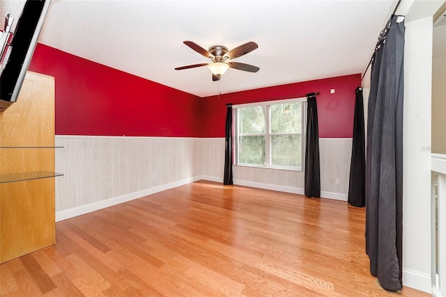 spare room with a textured ceiling, ceiling fan, and light hardwood / wood-style floors