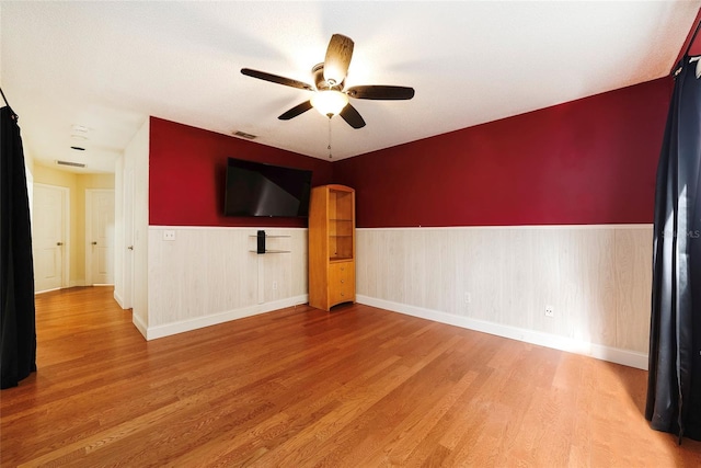 unfurnished living room with ceiling fan and wood-type flooring