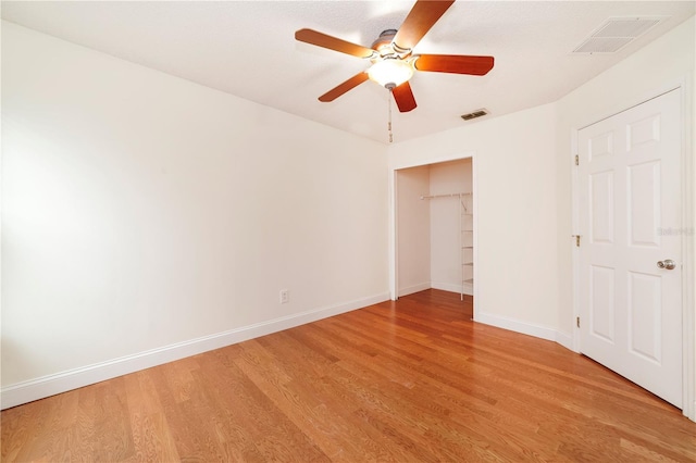 unfurnished bedroom with ceiling fan, a closet, and light hardwood / wood-style flooring