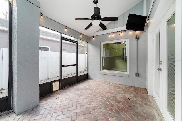 unfurnished sunroom featuring ceiling fan and lofted ceiling