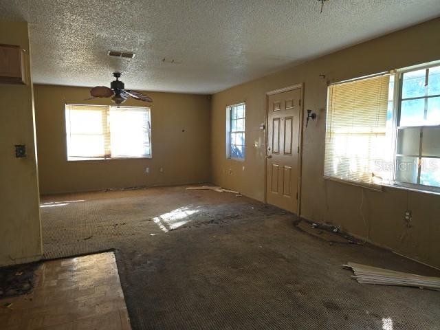 foyer with ceiling fan and a textured ceiling