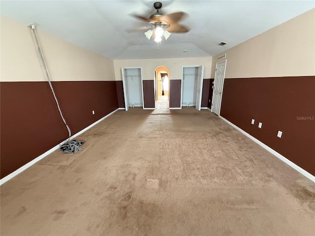 empty room with ceiling fan, lofted ceiling, and carpet