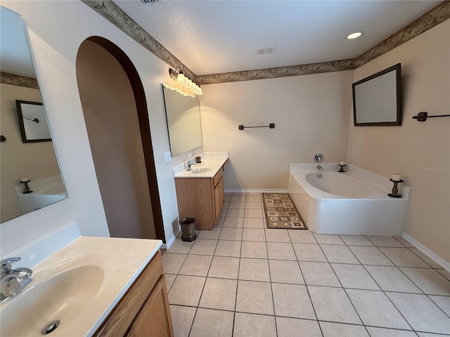 bathroom with tile patterned floors, a bathtub, and vanity