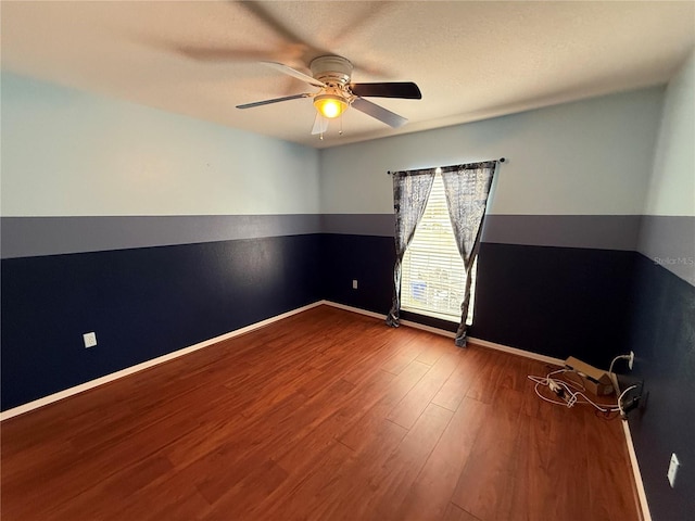 spare room featuring wood-type flooring and ceiling fan