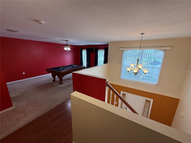 interior space featuring dark carpet, a chandelier, and a textured ceiling