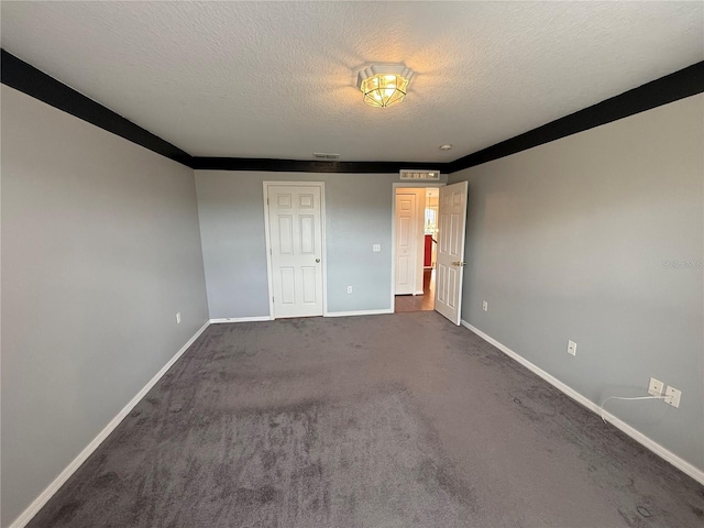 unfurnished bedroom with dark carpet and a textured ceiling