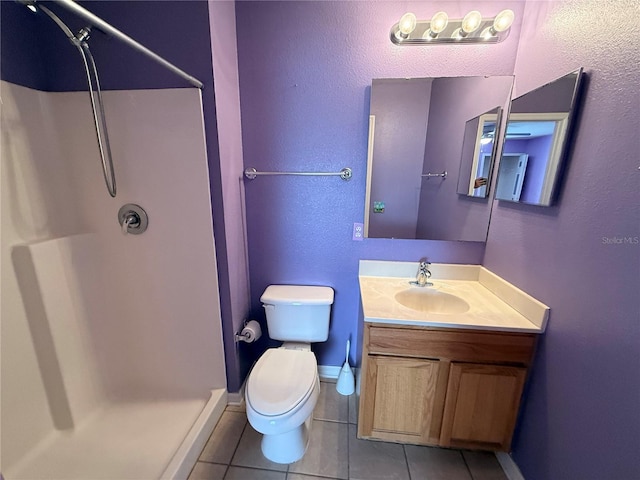 bathroom featuring tile patterned flooring, toilet, vanity, and walk in shower