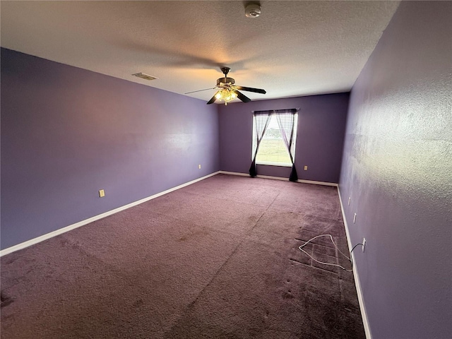 carpeted empty room with ceiling fan and a textured ceiling