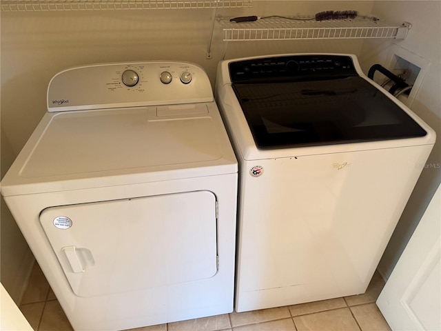 laundry area featuring light tile patterned floors and independent washer and dryer