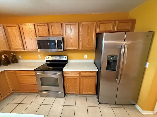 kitchen featuring light tile patterned flooring and appliances with stainless steel finishes