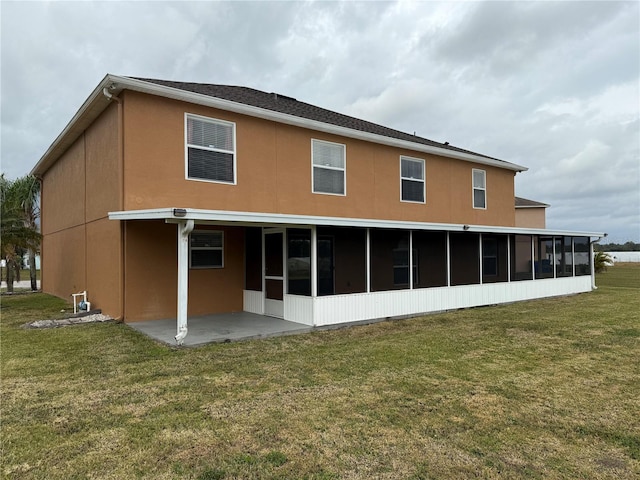 back of property with a sunroom, a yard, and a patio area