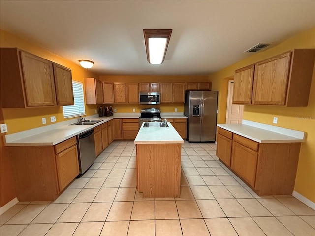 kitchen with appliances with stainless steel finishes, a center island, sink, and light tile patterned floors