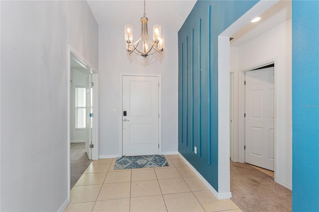 foyer entrance with an inviting chandelier and light carpet