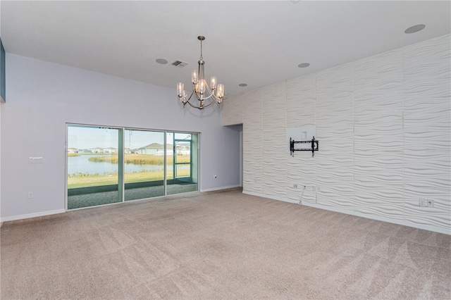 carpeted empty room with a water view and a notable chandelier