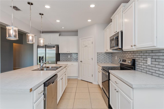 kitchen with sink, white cabinetry, stainless steel appliances, a center island with sink, and decorative light fixtures