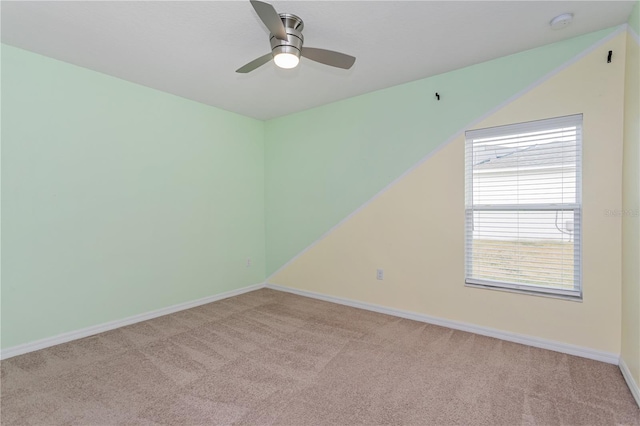 carpeted spare room with ceiling fan