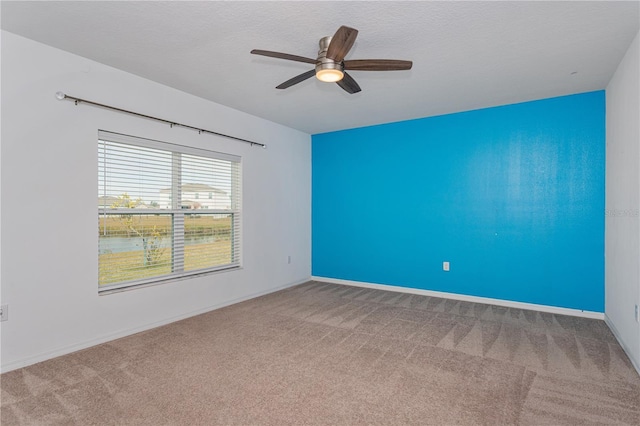 unfurnished room with carpet flooring, a textured ceiling, and ceiling fan