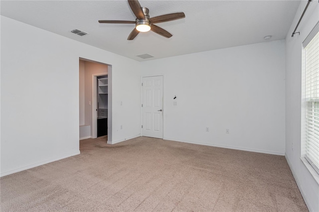 carpeted spare room with ceiling fan