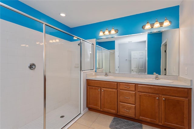 bathroom with a shower with door, vanity, and tile patterned flooring