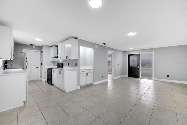 kitchen featuring sink, stainless steel fridge, white cabinetry, light tile patterned flooring, and black range with electric cooktop