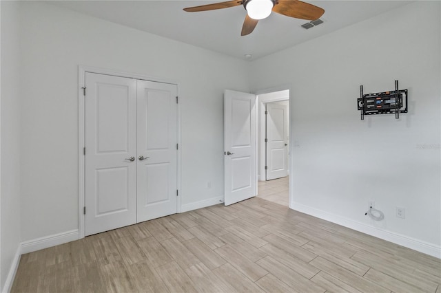 unfurnished bedroom featuring ceiling fan, a closet, and light hardwood / wood-style floors