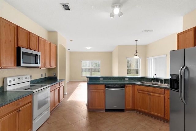 kitchen featuring sink, ceiling fan, tile patterned flooring, hanging light fixtures, and stainless steel appliances