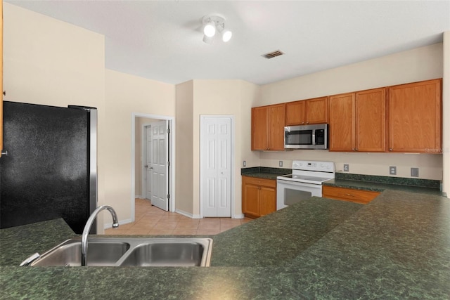 kitchen featuring light tile patterned flooring, appliances with stainless steel finishes, and sink