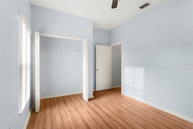 unfurnished bedroom featuring light wood-type flooring, ceiling fan, and a closet