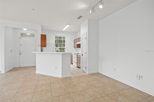 kitchen with white appliances, rail lighting, and light tile patterned floors