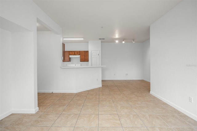 tiled spare room featuring rail lighting