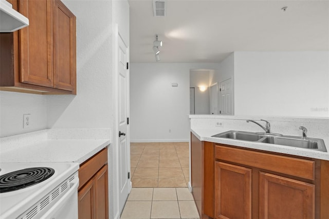 kitchen with track lighting, range hood, sink, and light tile patterned floors