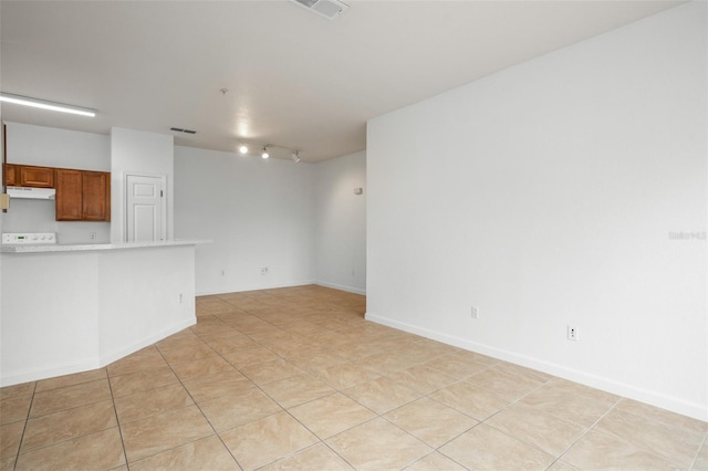 unfurnished living room featuring light tile patterned floors and rail lighting