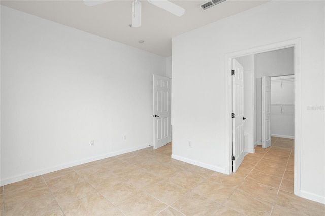 tiled spare room with ceiling fan