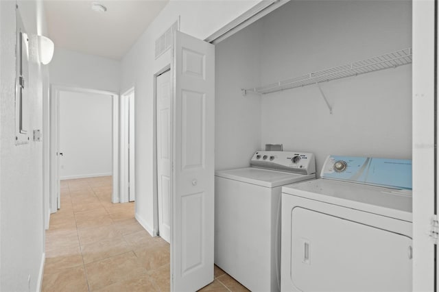 washroom with separate washer and dryer and light tile patterned floors