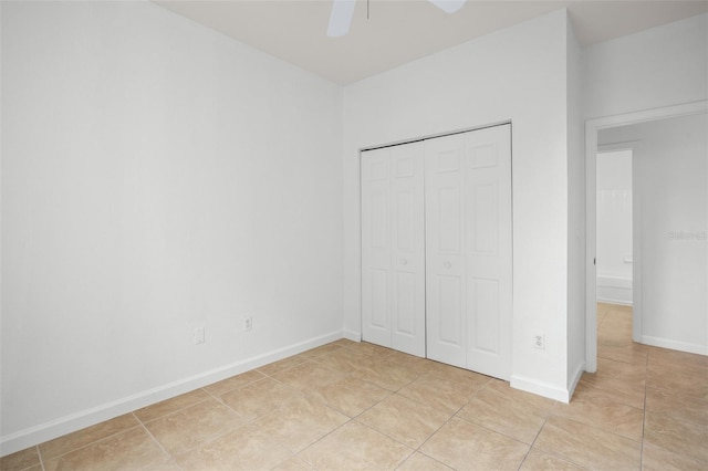 unfurnished bedroom with light tile patterned floors, a closet, and ceiling fan