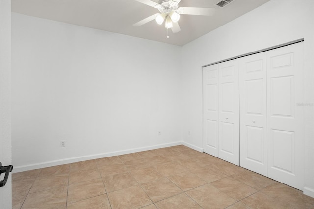 unfurnished bedroom featuring light tile patterned flooring, ceiling fan, and a closet