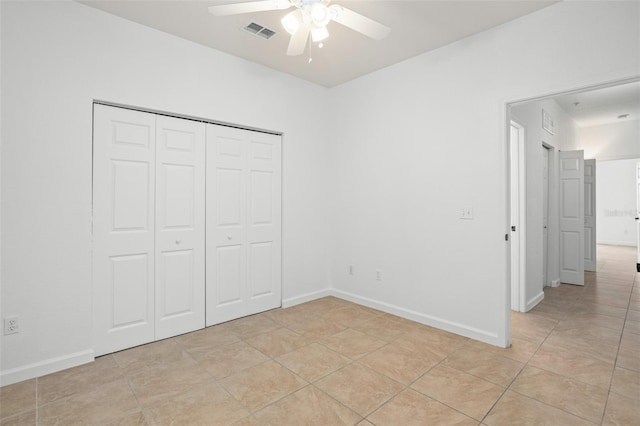 unfurnished bedroom featuring light tile patterned floors, ceiling fan, and a closet