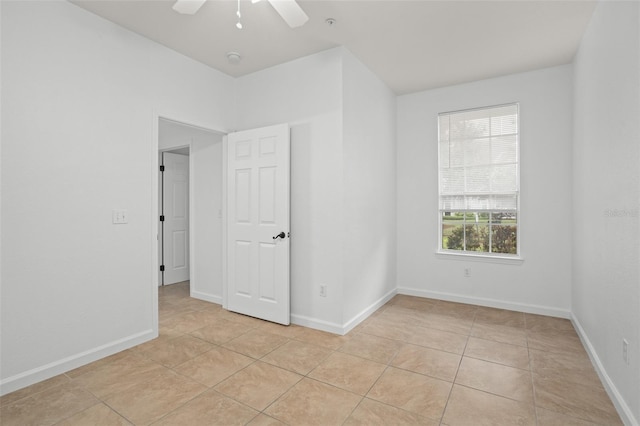 empty room featuring light tile patterned flooring and ceiling fan