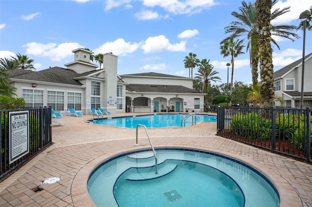 view of pool with a hot tub and a patio