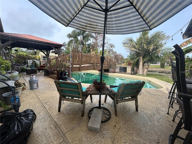 view of patio with a fenced in pool and a gazebo