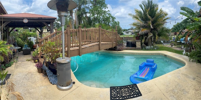 view of swimming pool featuring a deck and a gazebo