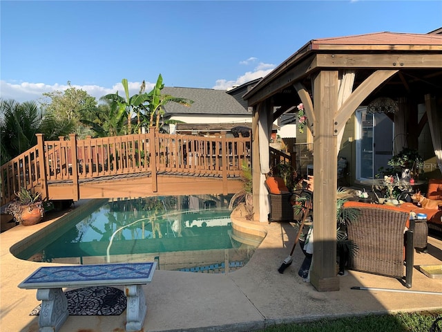 view of pool with a deck, a gazebo, an outdoor living space, and a patio