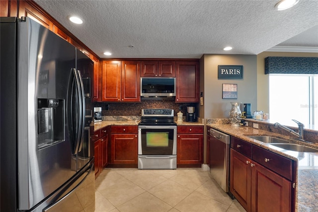 kitchen featuring light tile patterned flooring, sink, a textured ceiling, stainless steel appliances, and ornamental molding