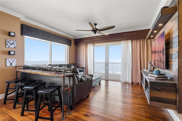 living room featuring a water view, dark hardwood / wood-style floors, and crown molding