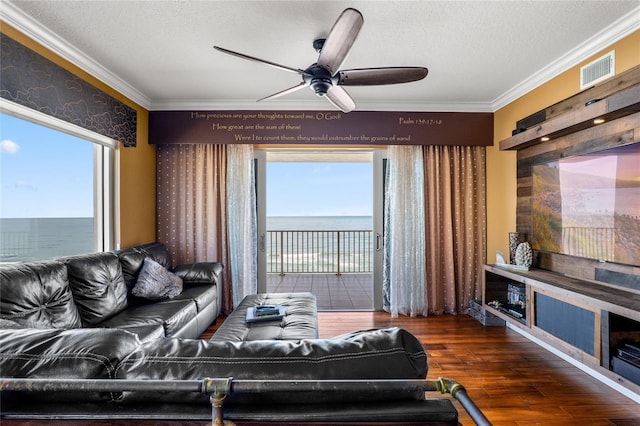 living room with a water view, dark wood-type flooring, a textured ceiling, and ornamental molding