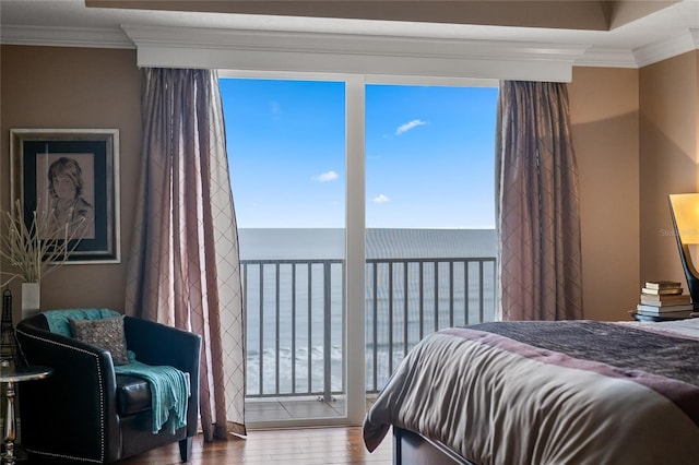 bedroom with a water view, crown molding, and hardwood / wood-style floors