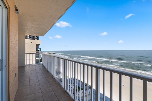 balcony with a water view and a beach view