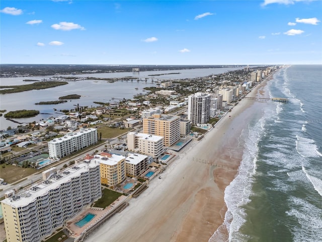 birds eye view of property featuring a water view and a beach view