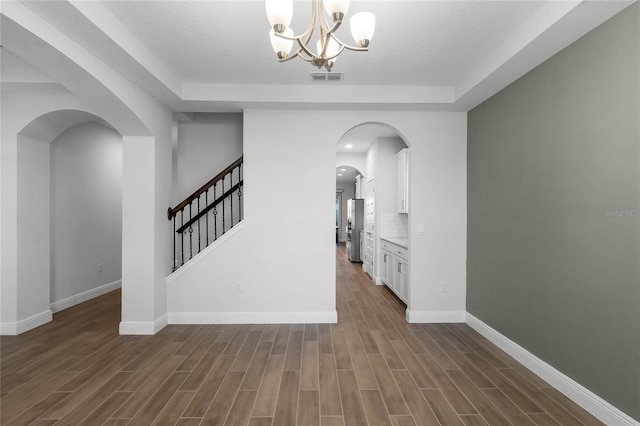 corridor with dark hardwood / wood-style floors and a chandelier